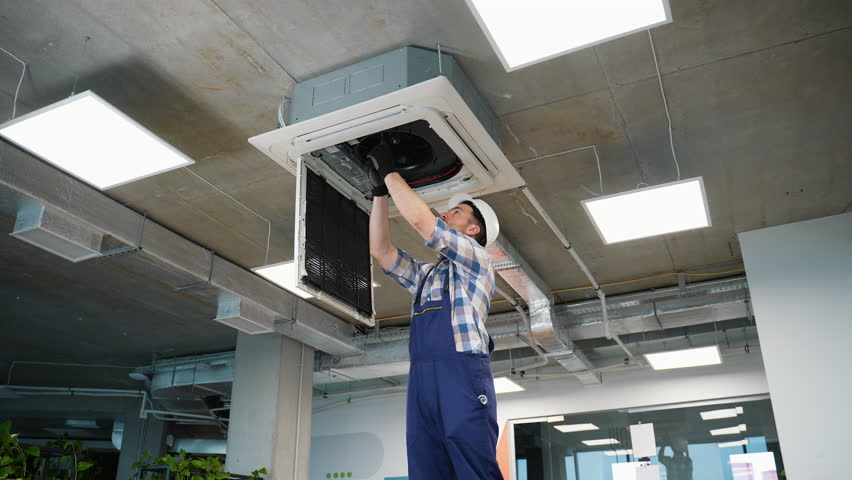 Professional hvac technician installing cassette type air conditioner