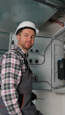 Electrician giving thumbs up after successfully completing work on electrical panel