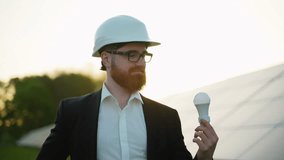 Scandinavian engineer showing light bulb in solar power plant - Powered by Shutterstock - Get 15% off with code: PIKWIZARD15