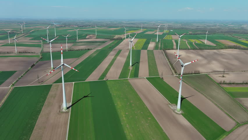 Aerial view of wind turbines and agriculture fields. Windmills turbines generating electricity, green energy, 4k