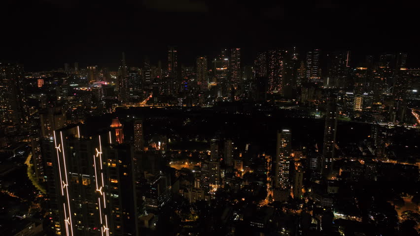 Aerial view of Mumbai city at night showcasing the illuminated skyline and urban cityscape. Central Mumbai landmarks visible include Lalbaug-Parel, Lower Parel, Worli, Curry Road, and Prabhadevi.