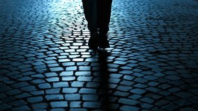 Businessman walking on cobblestone street at night. Businessman's elegant legs striding along shadowy cobblestone street, illuminated by streetlight, conveying urban solitude - Powered by Shutterstock - Get 15% off with code: PIKWIZARD15
