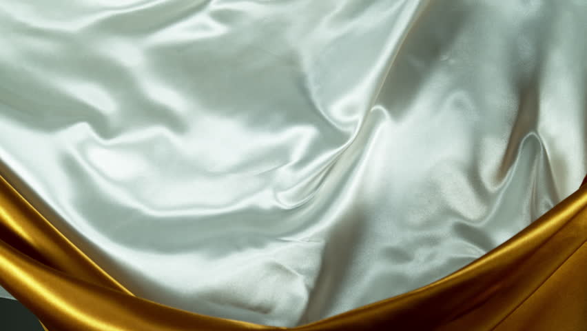 Super Slow Motion of Waving Golden and White Satin Cloth. Filmed on High Speed Cinema Camera, 1000 fps. Isolated on White Background.
