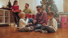 Multigenerational family sharing christmas gifts near sparkling tree, expressing joy and excitement during festive holiday gathering at home - Powered by Shutterstock - Get 15% off with code: PIKWIZARD15