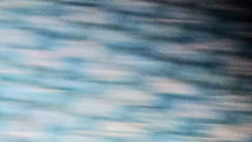 Abstract video featuring dynamic motion blur. Blue and beige streaks create a textured, dreamy effect. Fast camera movement. Visual style is blurry and abstract.