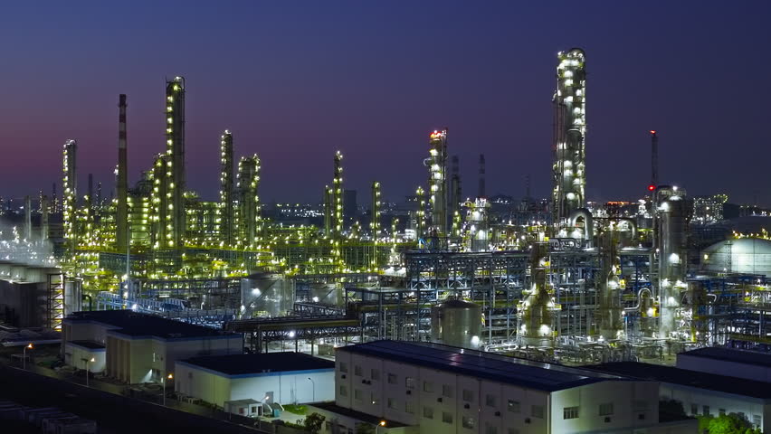 Aerial shot of an oil refinery and chemical plant with illuminated industrial equipment at night 