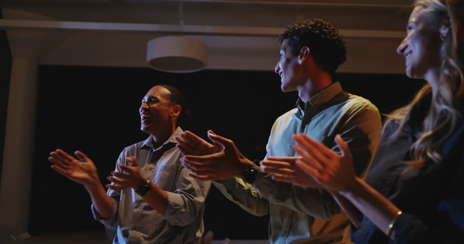 Business diverse team clapping and celebrating success during night meeting at office. teamwork, celebration, achievement, collaboration