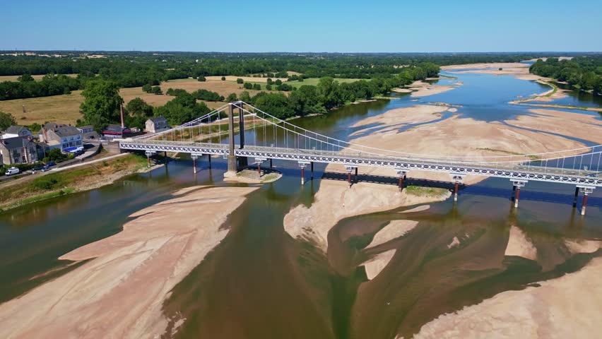 Varades suspension bridge over Loire River, low water level and large sandbanks, France. Aerial drone lateral view