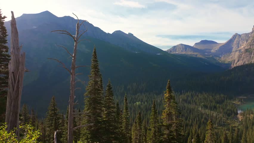 A scenic view of the turquoise Grinnell Lake seen from a hiking trail in the Many Glacier area of Glacier National Park