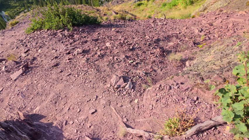 A scenic view of the turquoise Grinnell Lake seen from a hiking trail in the Many Glacier area of Glacier National Park