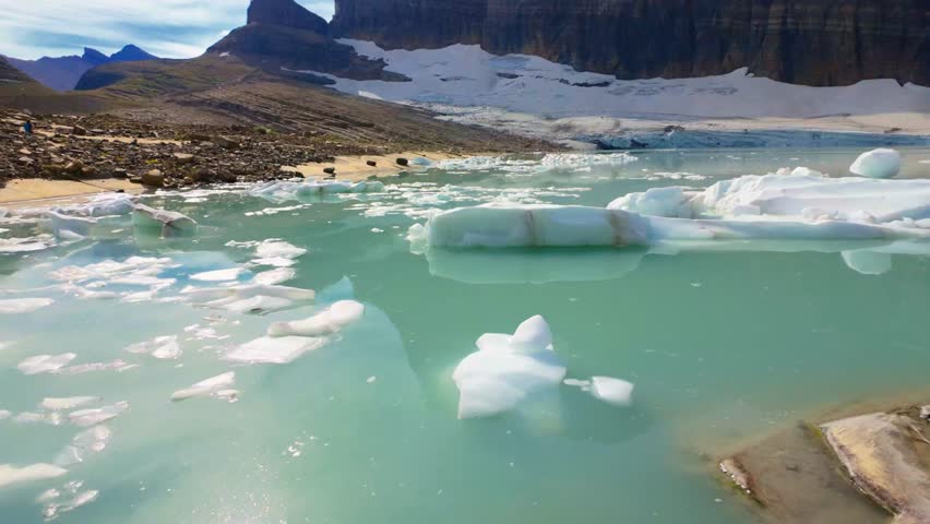 A stunning panoramic view of Upper Grinnell Lake with floating icebergs and the majestic Grinnell Glacier