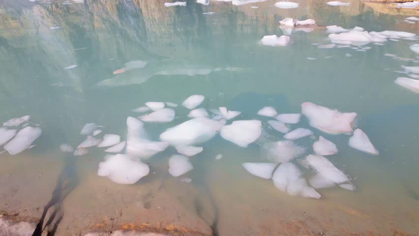 A stunning panoramic view of Upper Grinnell Lake with floating icebergs and the majestic Grinnell Glacier