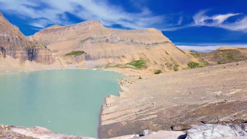 A stunning panoramic view of Upper Grinnell Lake with floating icebergs and the majestic Grinnell Glacier