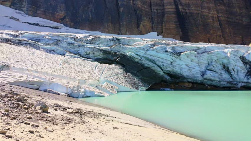 A stunning panoramic view of Upper Grinnell Lake with floating icebergs and the majestic Grinnell Glacier