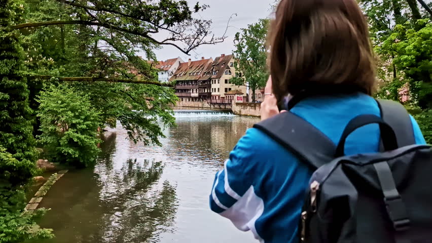 Woman Takes Pictures Of Pegnitzwehr in Nuremberg, Germany. - wide shot