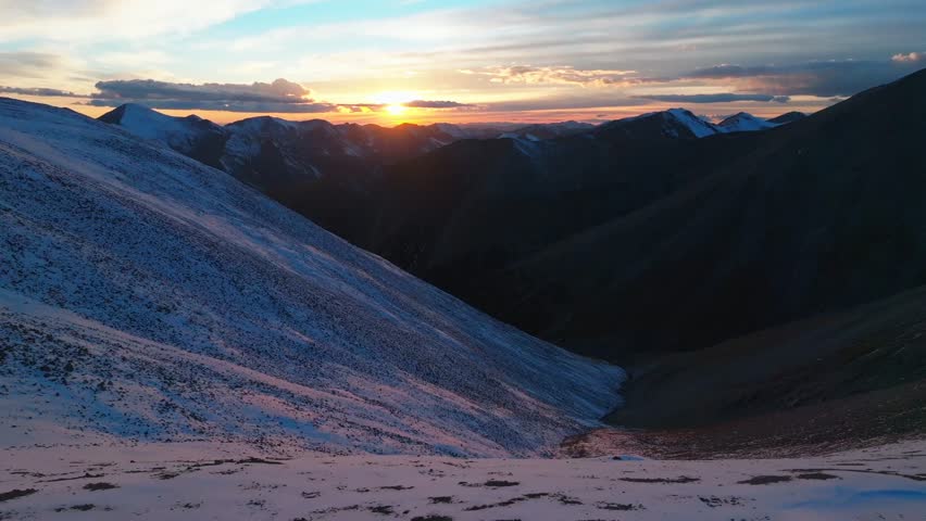 Rocky Mountains sunset Mt Mount Shavano Elbert Huron La Plata Tabeguache Antero Peak Colorado aerial drone fall autumn snow Sawatch Range top of summit sun on horizon clouds forward pan up motion
