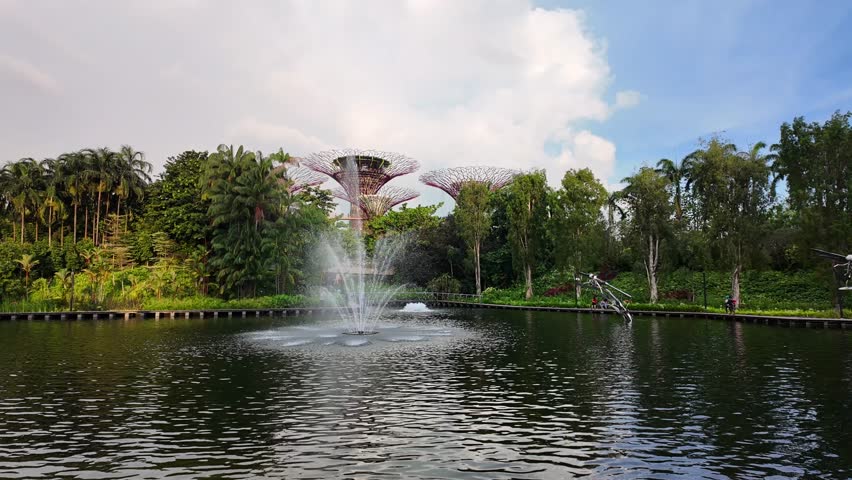 SINGAPORE, SINGAPORE - 27th SEPTEMBER 2024: View across Dragonfly Lake to Supertree Grove in Gardens By The Bay, Singapore.With fountain