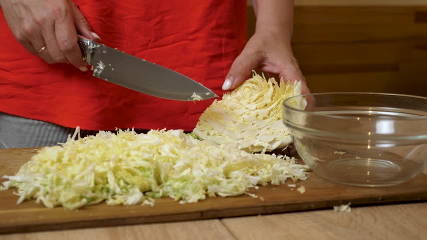 Cabbage is finely chopped with a knife. Preparing dishes from fresh cabbage.