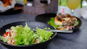 Child girl eating hamburger, salad, French fries, orange juice. Burger and vegetables for lunch at the table in a restaurant indoor. Healthy lettuce wraps with cucumber, bell pepper, herbs, cheese - Powered by Shutterstock - Get 15% off with code: PIKWIZARD15