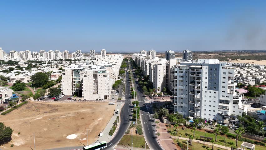 Aerial 4K drone footage of a main street in Ashdod, showing traffic, buildings, and urban life from above.