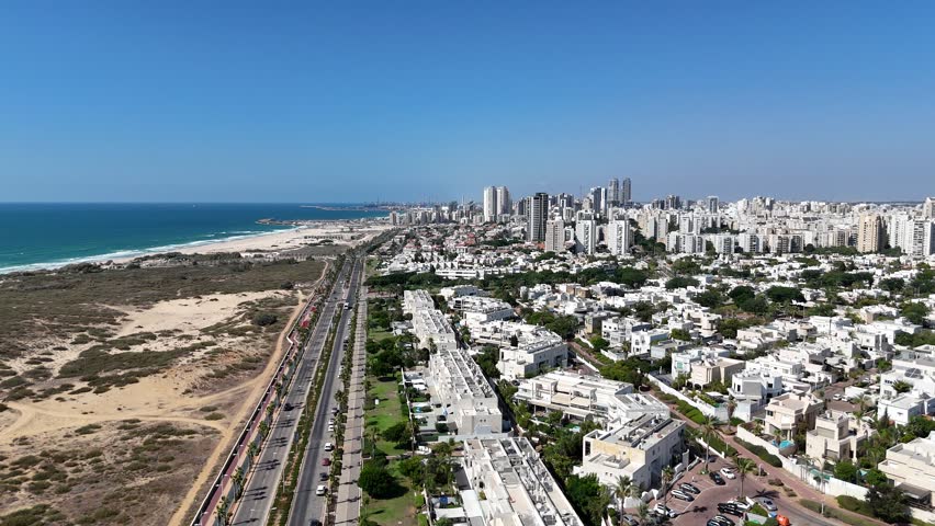 4K aerial drone footage of the coastal road in Ashdod, showing the highway alongside the Mediterranean Sea and urban scenery.