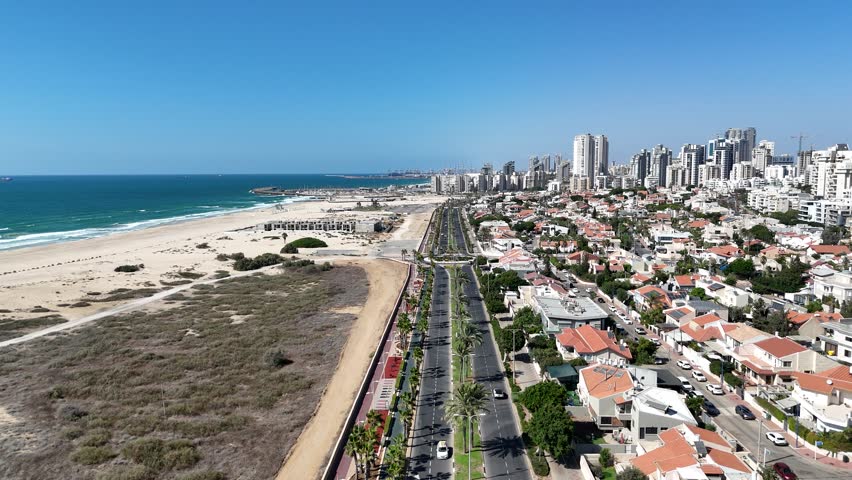 Aerial 4K drone footage of Ashdod city, showing the urban landscape, streets, buildings, and coastal views from above.