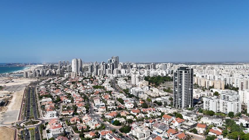 4K drone aerial view of Ashdod, highlighting the city streets, buildings, and Mediterranean coastline.
