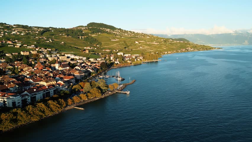 Aerial view of Lutry, where terracotta rooftops meet the azure expanse of Lake Geneva, cradled by verdant vineyards, Lutry, Vaud, Switzerland.