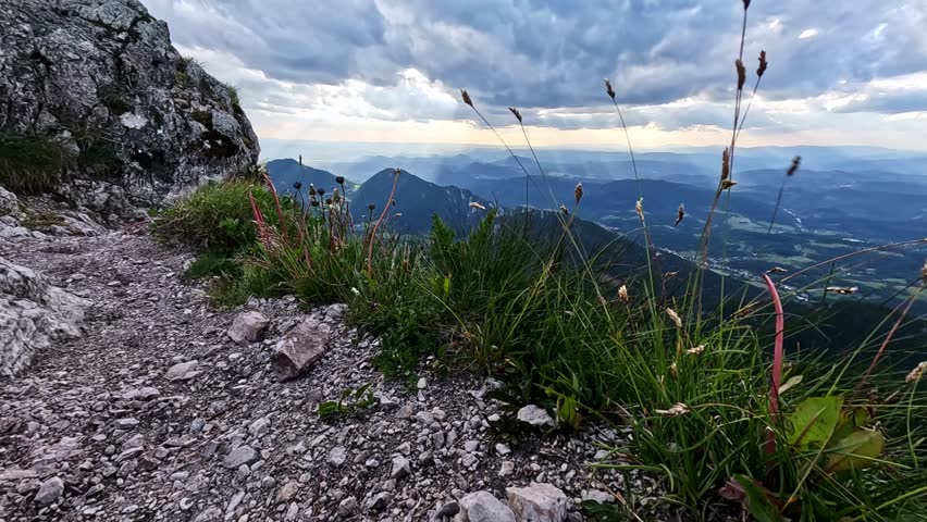 Slow-motion of dramatic clouds and wind-blown grass on a rocky mountain peak