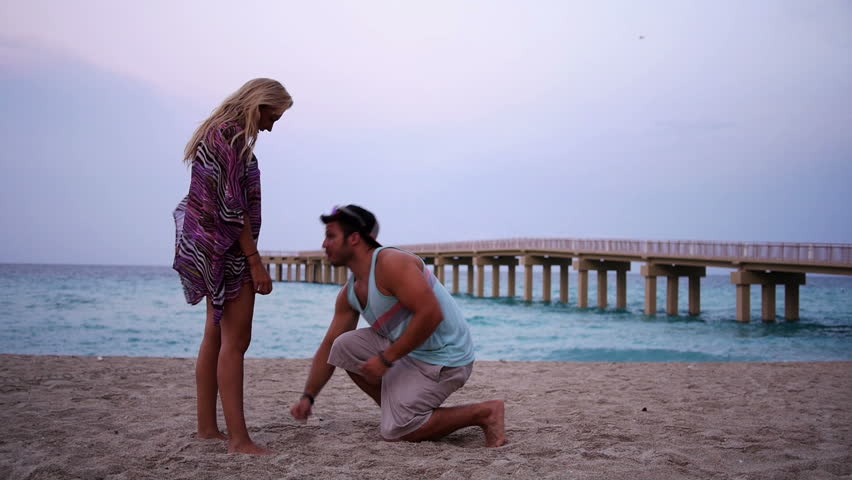 A man proposes on the beach.