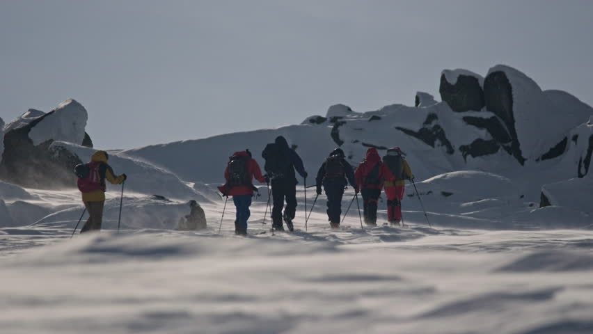 Winter expedition: mountaineers crossing snowy mountain pass