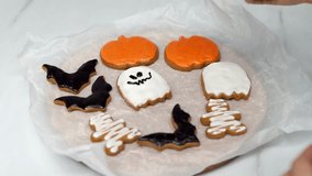 Women's hands coloring Halloween cookies. Halloween concept. Holiday atmosphere. Preparing for the Halloween party. 4k footage. - Powered by Shutterstock - Get 15% off with code: PIKWIZARD15