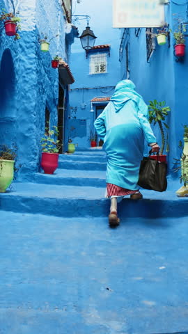 Old Moroccan Woman Walking In The Streets Of Chefchaouen, Morocco