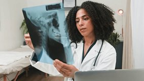 Professional Diverse Female Doctor Examining X-Ray During a Medical Consultation in Her Clinic - Powered by Shutterstock - Get 15% off with code: PIKWIZARD15