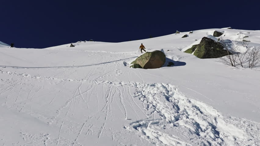 Freerider performing backflip jump on off-piste slope