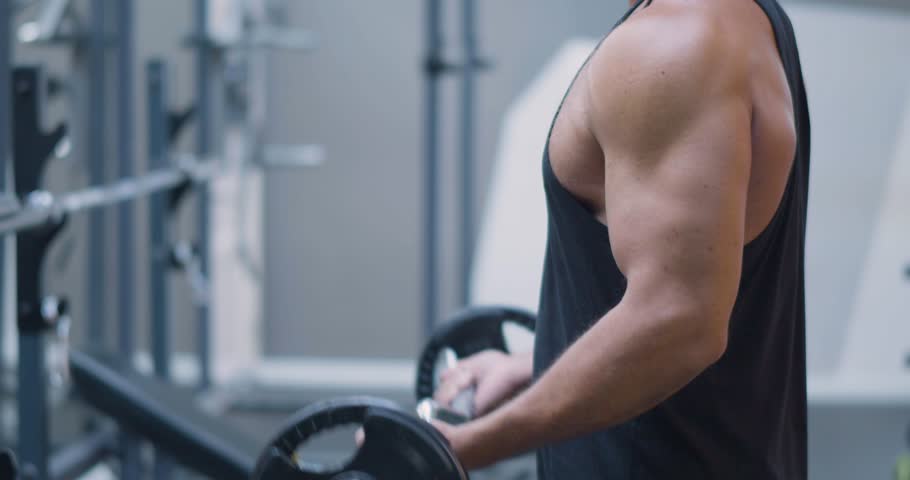 Gym workout. Bicep exercise. Middle aged Caucasian man trains his bicep muscles in the gym. Gym training focused on biceps as man lifts weights, building muscle mass and definition steadily.