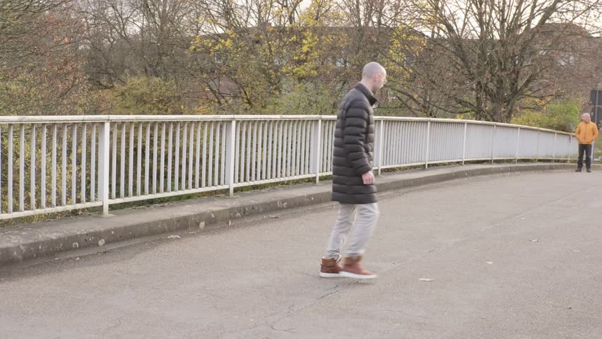Two men walking together, Happy Mature friends walking on bridge, Older father and young adult son, autumn walk, casual talk, active aging, adult relationship, warm bond, family connection