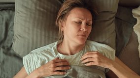 Close-up top view of mature 50s woman is turning in bed having nightmare trying to sleep. Tired Caucasian lady rolling at bedtime at home. Sleep deprivation, bad dream or nightmare - Powered by Shutterstock - Get 15% off with code: PIKWIZARD15