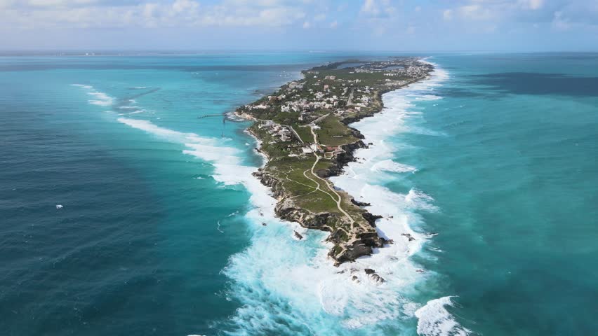 Aerial footage of Isla Mujeres highlights dramatic cliffs, turquoise seas, and tropical beauty along Mexico,s picturesque coastline.