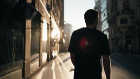 Silhouette of man walking through city street at sunrise with strong shadows. Represents reflection, balance, and vitality in modern urban lifestyle - Powered by Shutterstock - Get 15% off with code: PIKWIZARD15