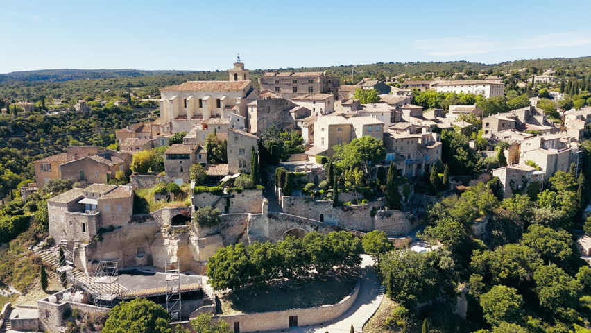 Drone shot of Gordes village with stone buildings, hilltop church and panoramic view over Luberon valley