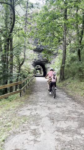 Father and daughter riding a tandem bicycle in a rural area