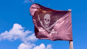 Tattered pirate flag with skull and crossed swords fluttering in wind against clear blue sky. Concept of pirate flag symbolizing danger, rebellion, adventure - Powered by Shutterstock - Get 15% off with code: PIKWIZARD15
