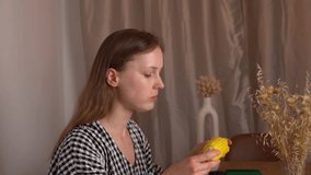 A young woman eats boiled corn on the cob in the living room, side view. Concept of healthy eating, natural food, vegetables, organic snacks, lifestyle, diet, vegetarian nutrition. - Powered by Shutterstock - Get 15% off with code: PIKWIZARD15