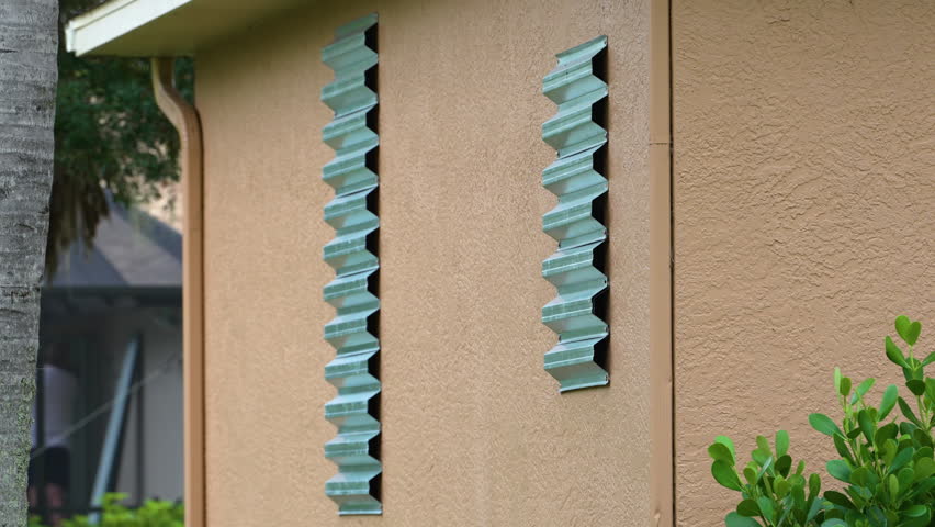 Hurricane shutters made from steel mounted for protection of house windows. Protective measures before natural disaster in Florida