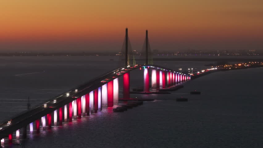 Transportation infrastructure of Florida, USA. Sunshine Skyway Bridge over Tampa Bay with driving traffic cars at night