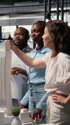 Vertical Video Diverse real estate developers analyze zoning regulations for construction, using 3D models for structural design and master plan. Site preparation and smart city infrastructure growth