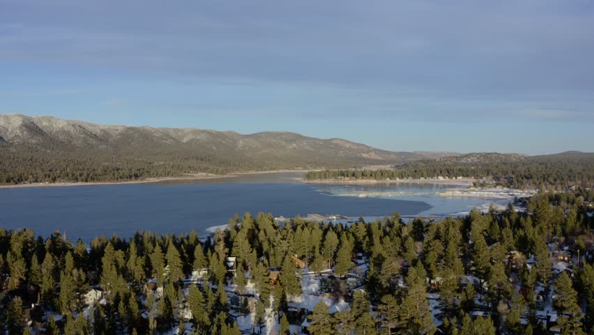Winter in Big Bear Lake, CA. Orbiting morning view of the lake, trees, and mountains. 