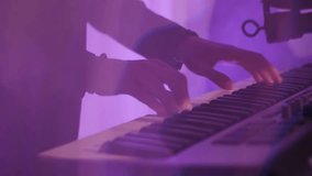 Close-up of a man's hands playing synthesizer keys in a nightclub in flashing neon light. Musicians play live music in a disco club. - Powered by Shutterstock - Get 15% off with code: PIKWIZARD15