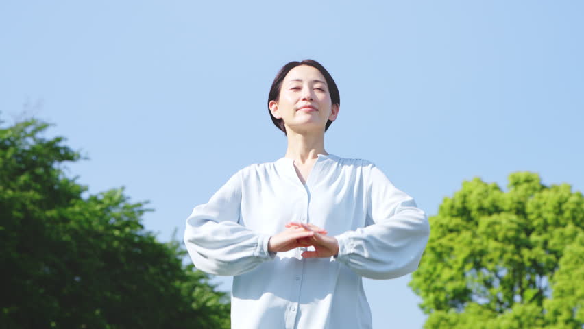 Japanese Woman Stretching Outdoors for Relaxation and Wellness
